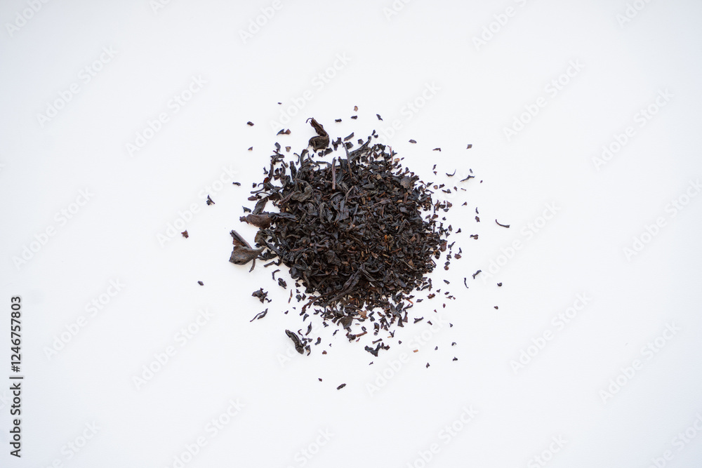a small pile of black and green tea lies on a white background