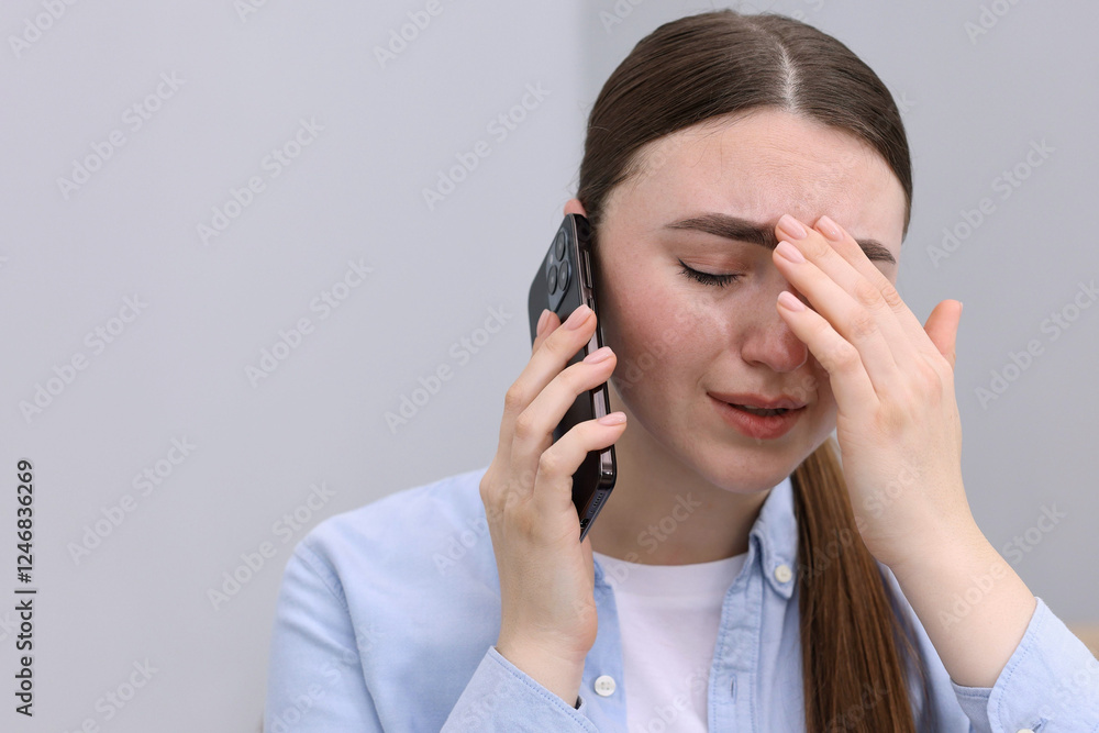 Stressed woman calling hotline for mental health help on grey background. Space for text Stressed woman calling hotline for mental health help on grey background. Space for text