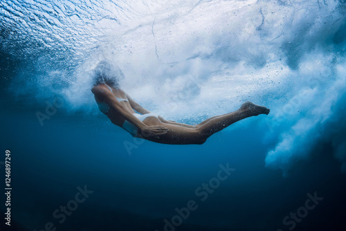 Wallpaper Mural Graceful woman swimming under water under crashing wave in crystal-clear ocean Torontodigital.ca