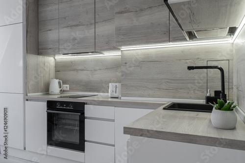 Картината върху платно Modern kitchen with cabinets and induction on counter, built-in oven, microwave