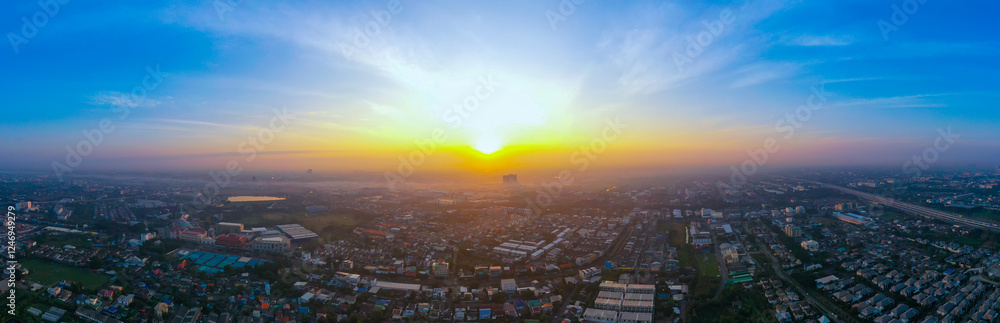 Fototapeta premium view of sunset city skyline, transportation with cars on Expressway, Road, Roundabout, multilevel junction highway-Top view. Important infrastructure, cloudscape, cityscape, building, crane.