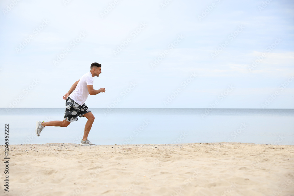Muscular man running on beach, space for text. Body training Muscular man running on beach, space for text. Body training