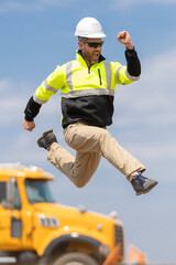 Builder man run fast to work. Engineer supervisor running outdoor. Supervisor jumping. Excited builder construction worker jumping in front of trucks. Man engineer running to success, copy space