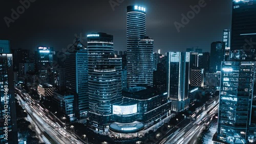 Nighttime traffic flows through a modern city illuminated by blue lights in a captivating time lapse
