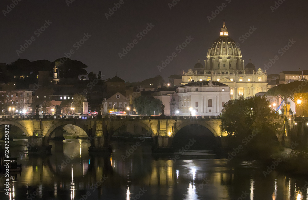 Fototapeta premium A night view of St. Peter's Basilica in the Vatican seen from across the Tiber River. The Ponte Sant'Angelo bridge is visible in the foreground, with its arches and reflections.