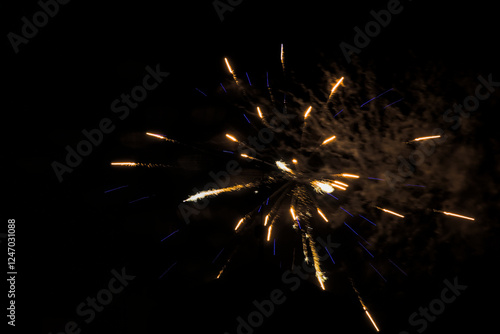 Bright bursts of simple fireworks illuminating the night sky.