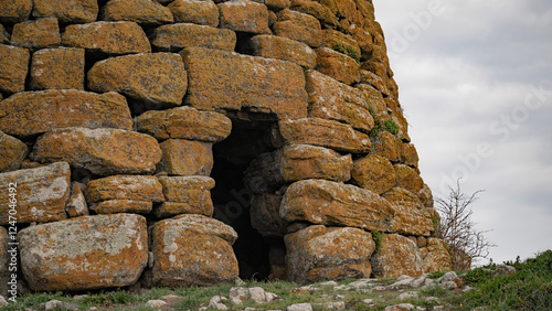 Historic nuraghe tower stands amidst the rugged sardinian landscape, showcasing ancient architecture and cultural heritage photo