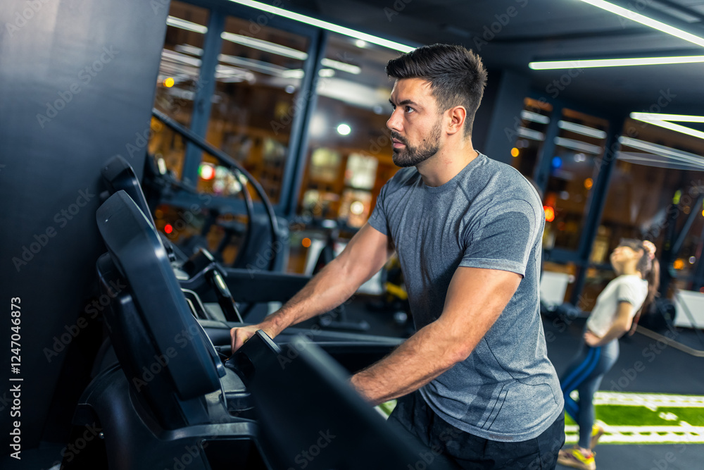 Muscular young man running on a treadmill in the gym. Muscular young man running on a treadmill in the gym.