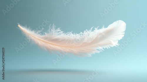 Soft white feather floating gracefully against a tranquil blue background in ...