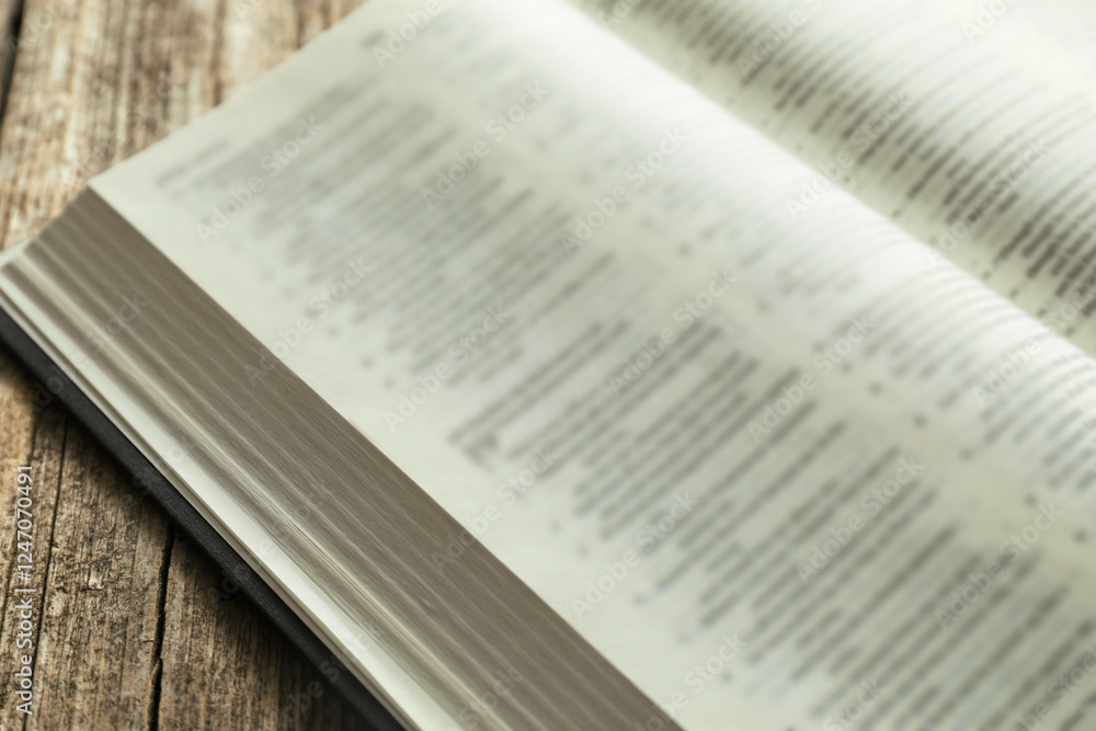 Obraz premium Open Holy Bible in English language on wooden table, closeup