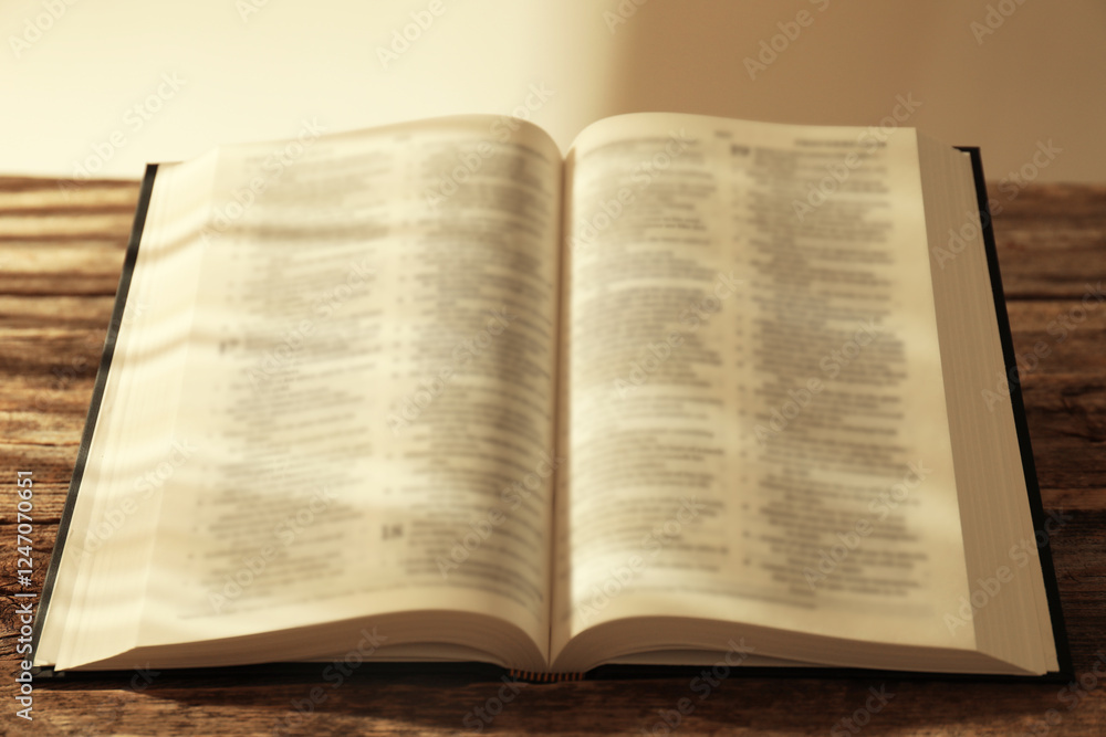 Obraz premium Open Holy Bible in English language on wooden table, closeup