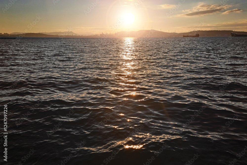 Obraz premium Sunset over dark water. Vibrant colors over the ocean horizon. Peaceful waves and golden sunlight reflecting on the water. Serene coastal landscape. Travel and relaxation. Scary power of the sea.