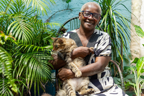 Foto Happy elderly black woman with her pet on her lap