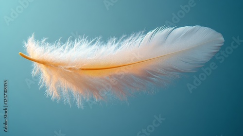 Soft white feather floating gracefully against a tranquil blue background in ...