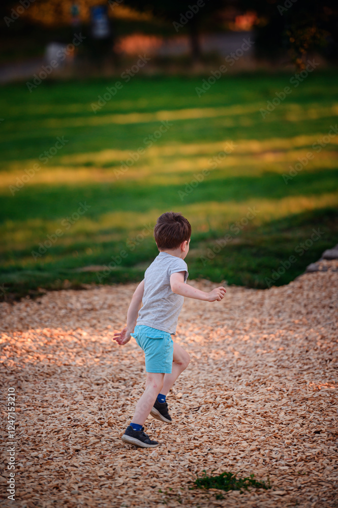 Young boy running at playground on a sunny day