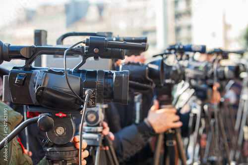 Multiple professional video cameras filming live media event, news or press conference