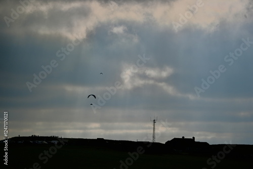 beechy head Eastbourne with an impressive dramatic sky and para-gliders in the background