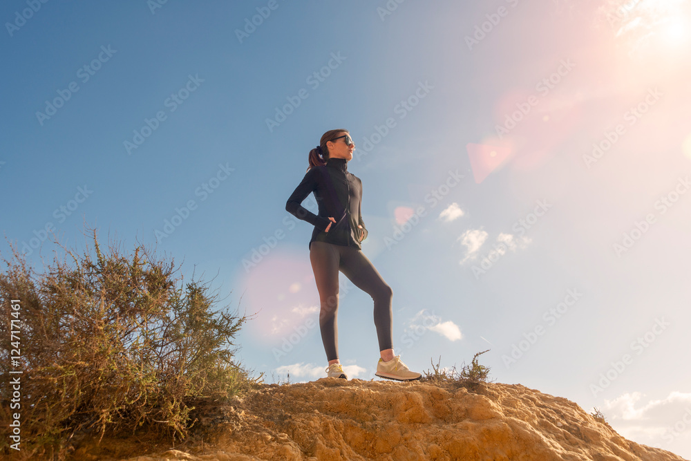 sporty woman standing on top of a cliff enjoying the view sporty woman standing on top of a cliff enjoying the view