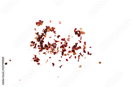 Dried chili flakes scattered on a plain background