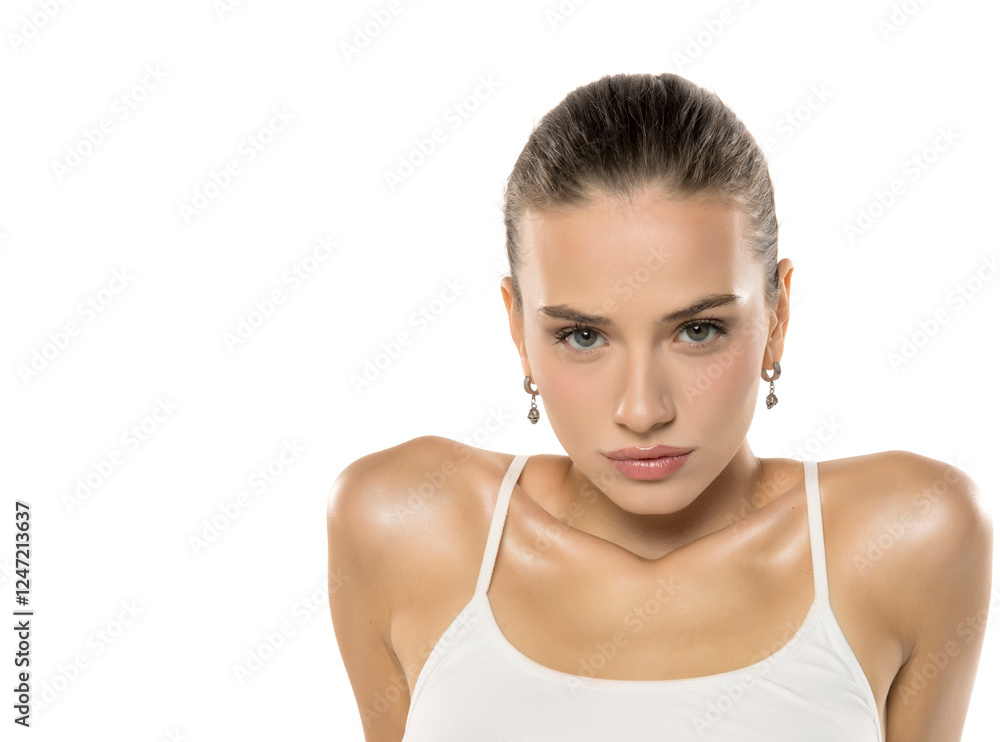 Professional beauty portrait with intense gaze. Model in white top conveys strength and confidence against clean studio background Professional beauty portrait with intense gaze. Model in white top conveys strength and confidence against clean studio background