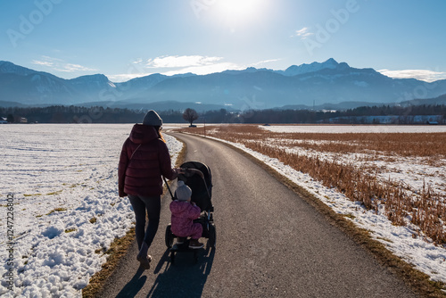 Loving other walks with baby stroller and young child along scenic mountain path in St. Egyden, Carinthia, Austria. Majestic Karawanks mountains creating breathtaking backdrop of natural alpine beauty