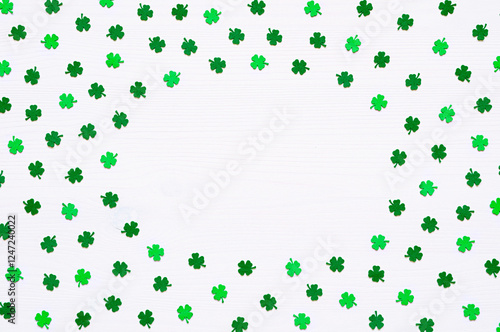 St Patrick's Day background. Green quatrefoils on the white wooden surface with free space for text, round border for St Patrick's day holiday photo