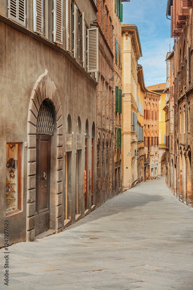 Obraz premium Old street in the historical center of Siena, the UNESCO World Heritage Centre unchanged for 13-14 centuries, with its medieval streets looked like in the early Middle Ages. Italy, 2019 