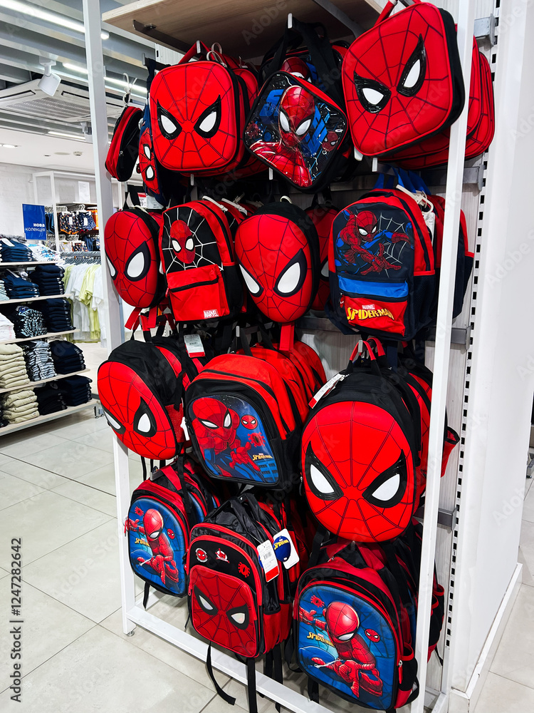 Naklejka premium Kyiv, Ukraine - February 05, 2025: Several colorful backpacks featuring Spider Man iconic superhero design displayed in a retail store