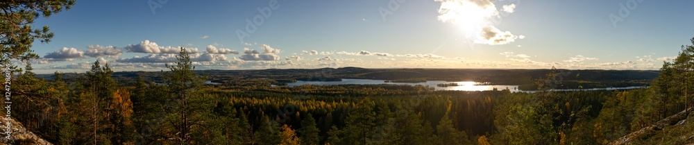 Fototapeta premium Expansive Sunset Panorama Over Nordic Forest and Lakes with Rolling Hills and Dramatic Cloudscape