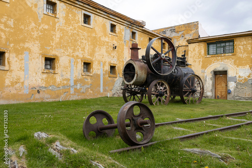 A well-preserved coal-powered machinery and train tracks with a wheeled axle