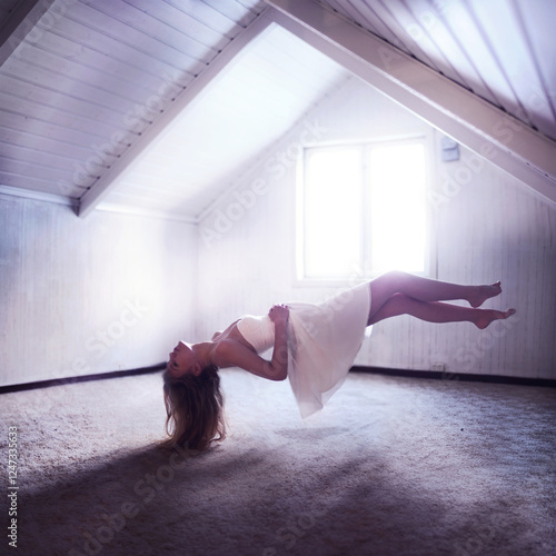 Side view of a Woman in a white dress Levitating In an empty Attic