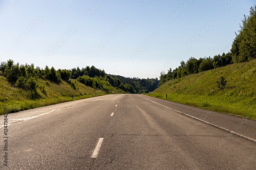 Fototapeta premium an empty straight paved road against a blue sky background