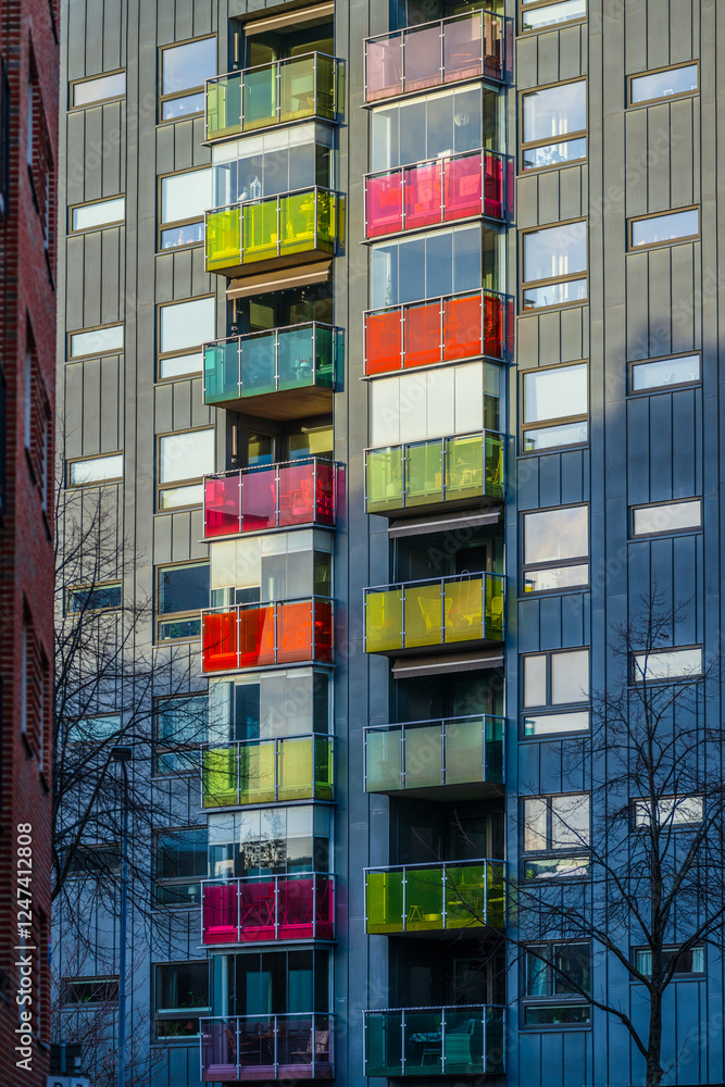 Fototapeta premium colorful balconies on modern residential building with glass panels.