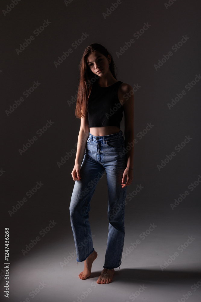 Model poses in casual outfit with a moody background during a studio shoot Model poses in casual outfit with a moody background during a studio shoot