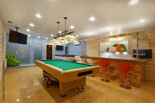 The interior of a room in a private house with a billiard table and a bar counter. photo