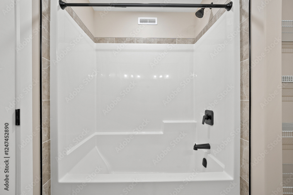 A white bathtub with a black faucet and a black shower head A white bathtub with a black faucet and a black shower head