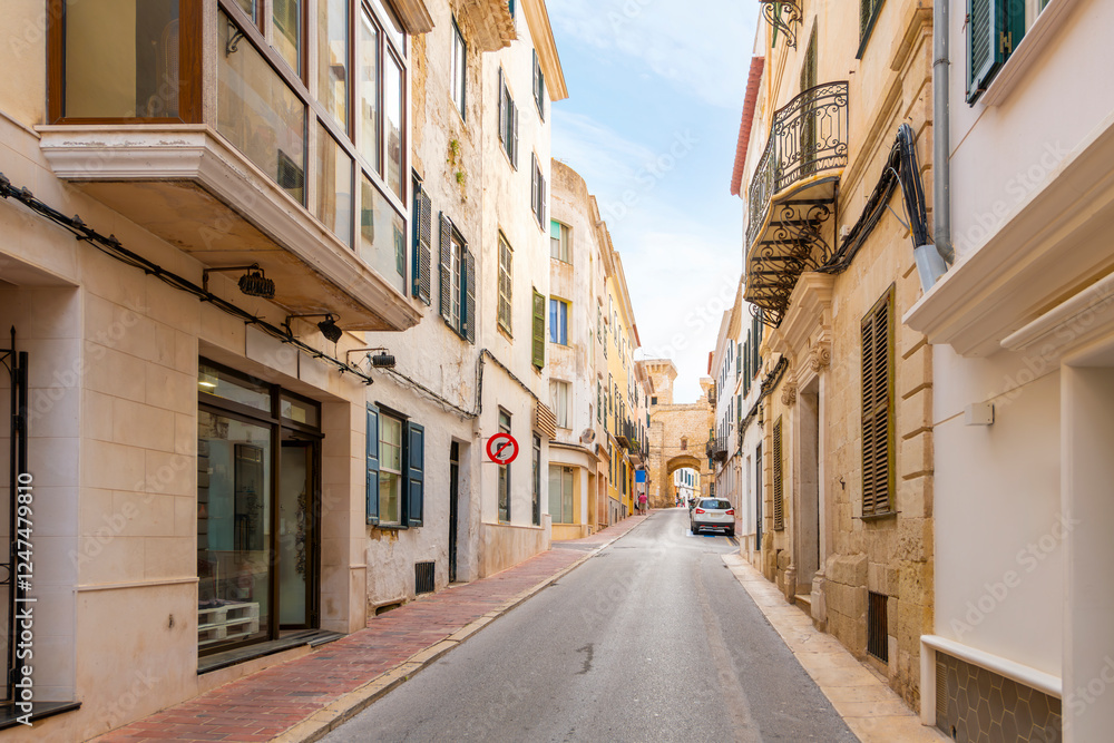 A street of apartments leads to the historic Portal de San Roque, the archway that is one of the last remnants of the old city walls of Mahón, Spain, on the Mediterranean island of Menorca. A street of apartments leads to the historic Portal de San Roque, the archway that is one of the last remnants of the old city walls of Mahón, Spain, on the Mediterranean island of Menorca.