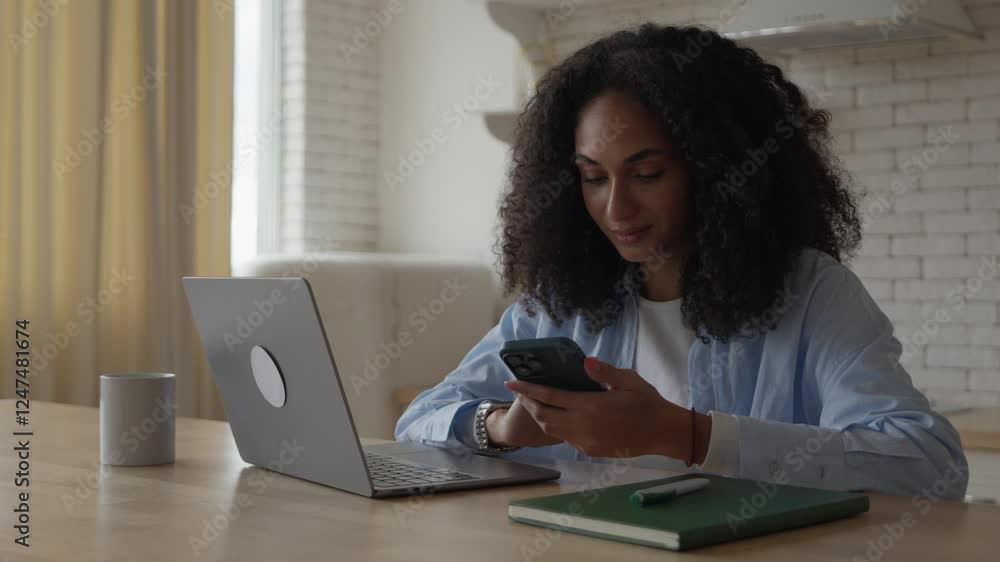 Smiling Young Woman Sitting in Kitchen and Using Smartphone in the Kitchen Smiling Young Woman Sitting in Kitchen and Using Smartphone in the Kitchen