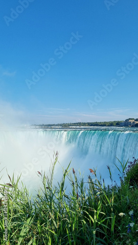 Niagara Falls. A pleasure boat with people near the huge famous waterfall. View from the Canadian side. Nature scenery. Photo for advertising