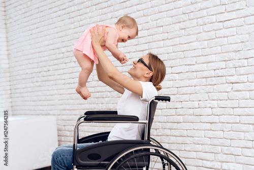 Mother in wheelchair play with newborn baby. Disabled, motherhood concept. photo