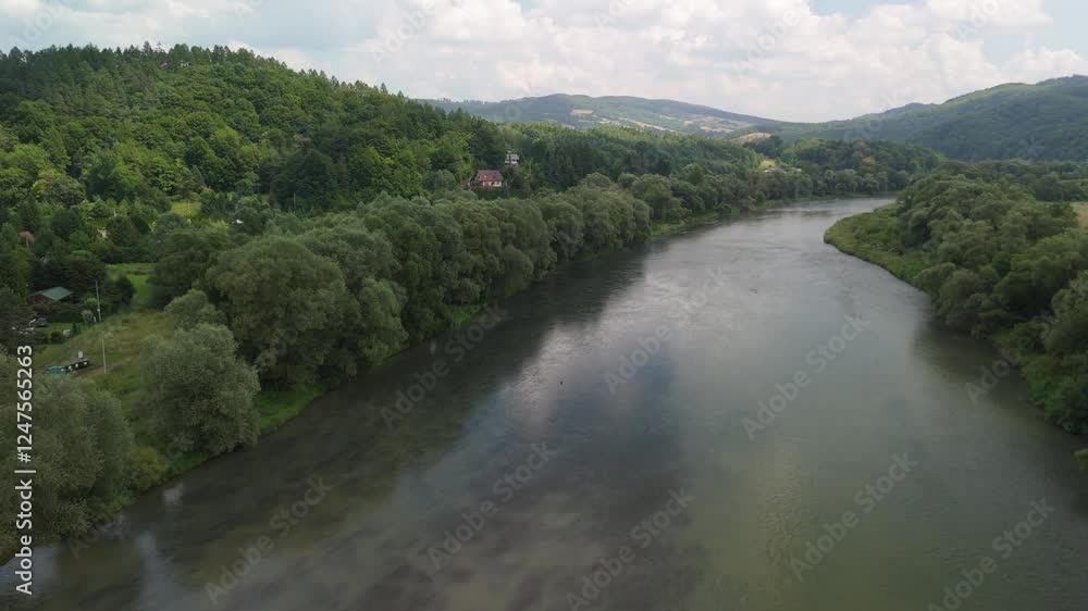 Aerial view of a winding river flowing through a lush valley, surrounded by dense trees and hills. Aerial view of a winding river flowing through a lush valley, surrounded by dense trees and hills.