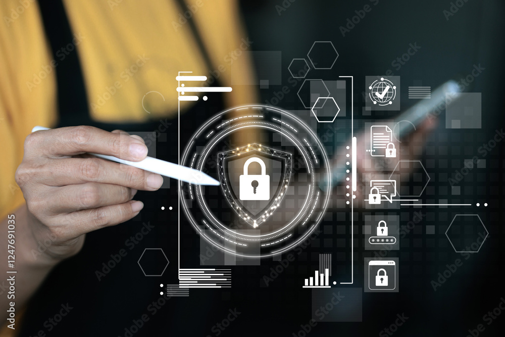 Obraz premium A person is holding a pen and pointing at a screen with a security symbol. The screen has a lot of icons and the person is looking at the screen