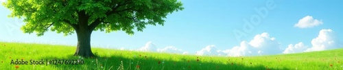 Tree in a green meadow with wildflowers swaying gently under a sunny blue sky, flowers, garden