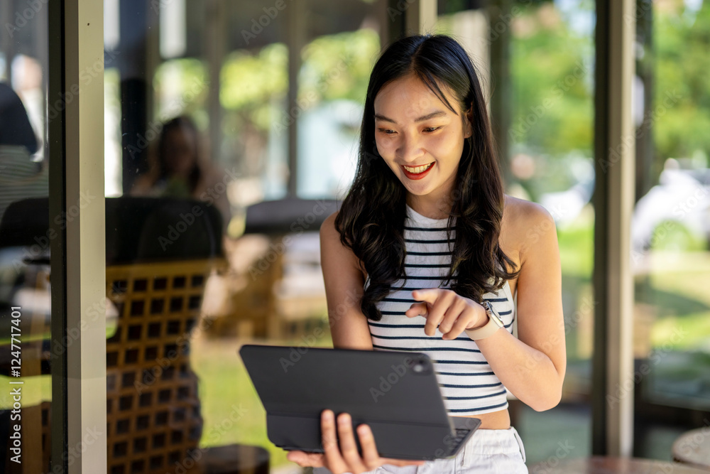 A woman is smiling and pointing at a tablet A woman is smiling and pointing at a tablet