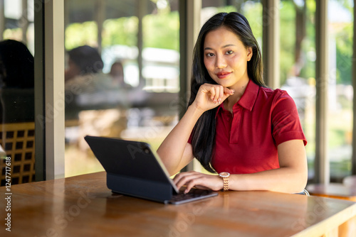 A woman is sitting at a table with a laptop in front of her Free Download A woman is sitting at a table with a laptop in front of her - GFXLoad