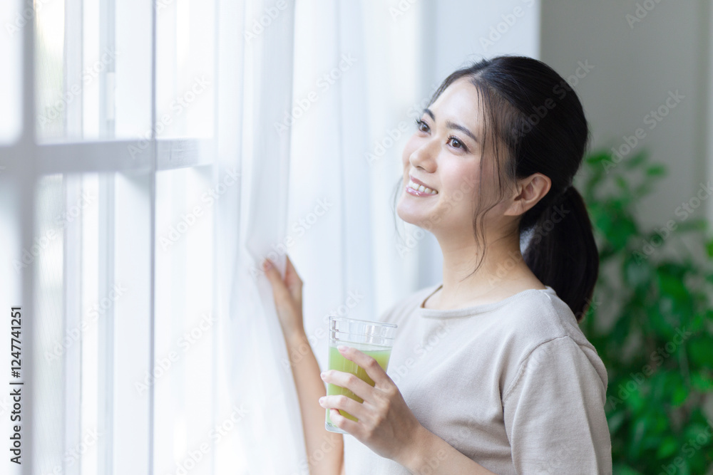 窓の外を眺める女性 窓の外を眺める女性