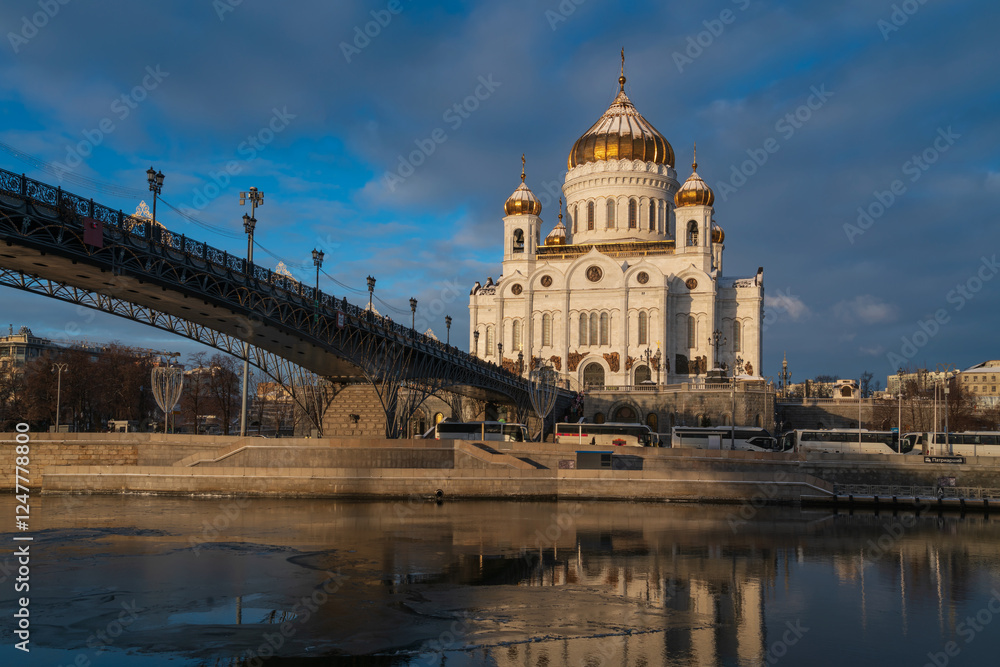 Fototapeta premium View of the Cathedral of Christ the Savior and the Patriarchal Bridge from the Beresnevskaya embankment of the Moskva River on a sunny winter day, Moscow, Russia