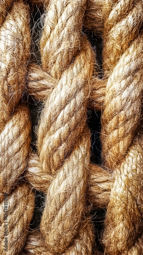Fototapeta premium Close-Up of Strong Natural Brown Rope Texture with Twisted Fibers and Rustic Artisanal Craftsmanship