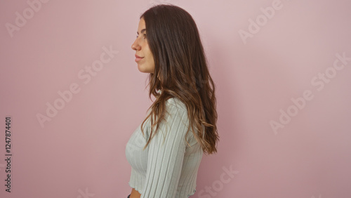 Konstfotografi Woman standing against an isolated pink background, capturing a beautiful young adult with brunette hair and an attractive profile