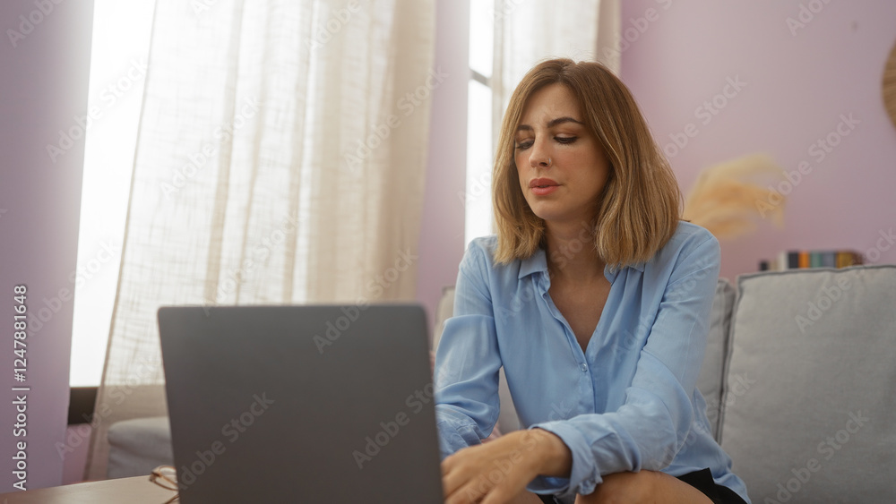 Young blonde woman working on a laptop in a cozy living room with soft lighting and casual decor Young blonde woman working on a laptop in a cozy living room with soft lighting and casual decor
